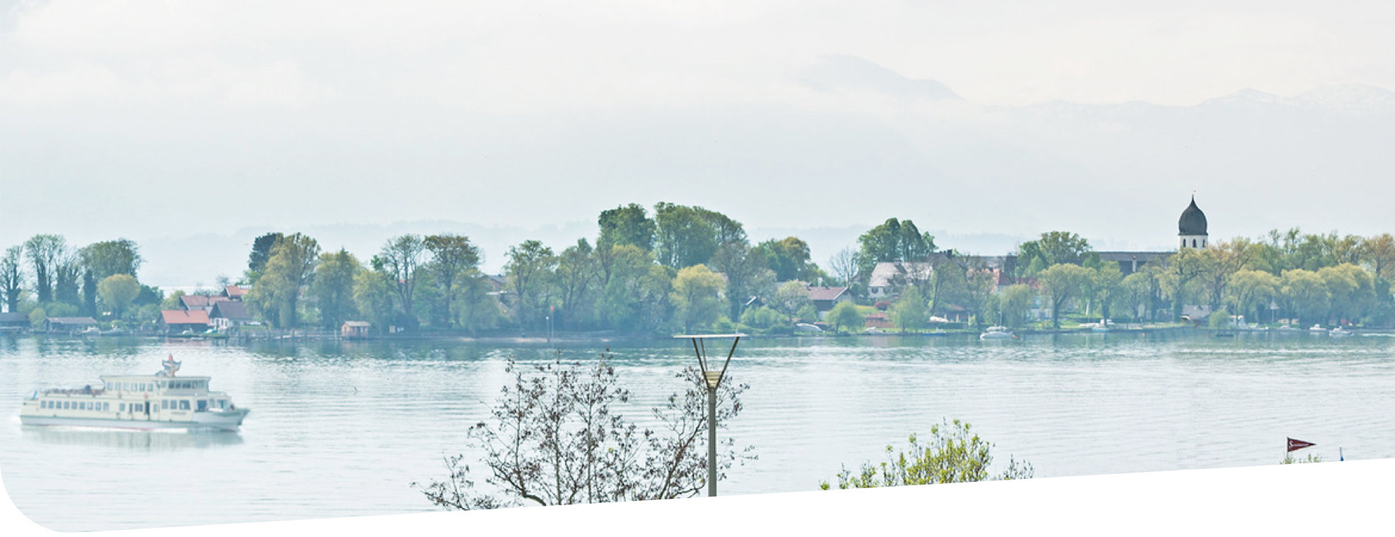 Verband Der Chiemsee mit Schiffen im Hintergrund eine Insel mit Kirche